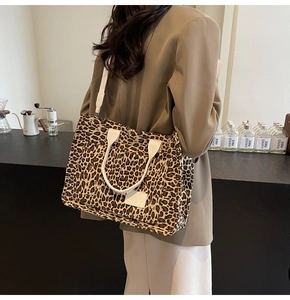 Close-up of leopard print canvas tote bag with white branded label and woven straps
