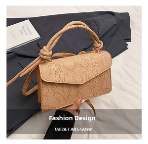 Detailed macro view of the cream-colored lace floral embossing on a chic crossbody bag