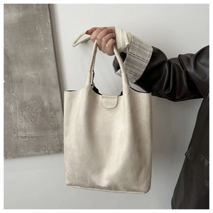 Detailed texture of off-white faux suede tote bag with soft matte finish and twin handles