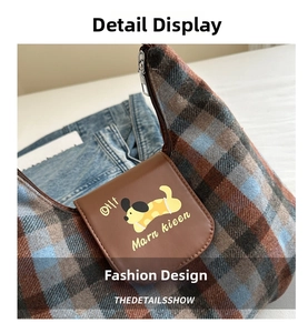 Dettaglio della borsa hobo in tweed a quadri con patta in pelle e stampa di cartone