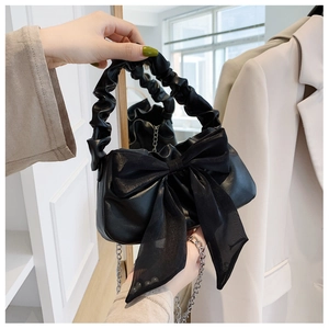 Detail of black cloud-style handbag with mesh bow and stylish ruched handle