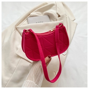 Detail of fuchsia felt underarm bag featuring geometric quilted stitching and gold zipper