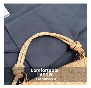 Detail of light beige crossbody bag with lace texture, decorative knot and gold hardware