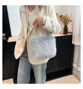 Plush light gray handbag with shoulder strap styled with white blazer and jeans