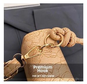 Detail of golden metal lobster clasp and textured fabric on stylish crossbody bag