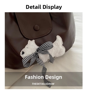 Macro detail of a dark brown leather bag with a cute white puppy plush patch and bow
