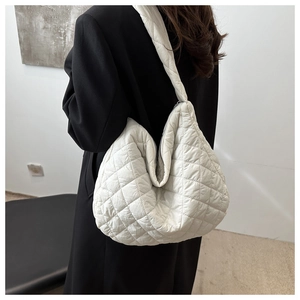 Detail of white quilted puffer shoulder bag with diamond stitching and soft nylon texture