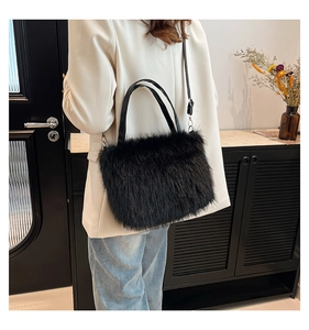 Model view of black faux fur tote bag with leather handles and adjustable shoulder strap
