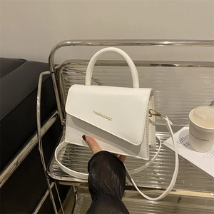 Sac bandoulière trapèze blanc minimaliste avec texte doré et poignée supérieure
