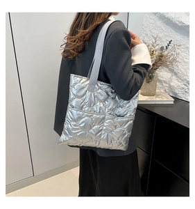 Detailed shot of silver quilted tote bag with front pockets and metallic finish textile