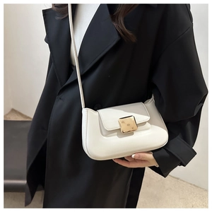 Detail of minimalist beige leather shoulder bag with a large gold square buckle