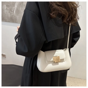 Close-up of minimalist beige leather shoulder bag with distinct golden square metal buckle