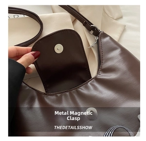 Detail shot of the vintage brown hobo bag showing the magnetic metal buckle and zipper