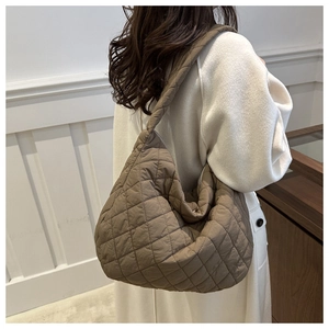Detail of a brown quilted tote bag showing its soft padded texture and rhombus stitching