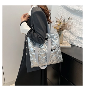Détail du sac cabas matelassé argenté avec broderie en losanges et bandoulière en tissu