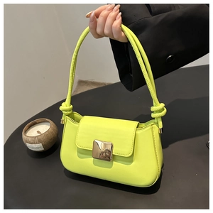 Detail of neon green shoulder bag featuring a gold square buckle and knotted strap