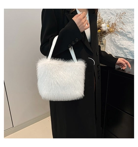 Detailed view of plush white faux fur shoulder bag with soft leather handle straps