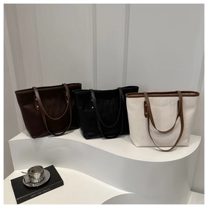 Detailed view of large tote bags in brown and black with embossed rectangular texture