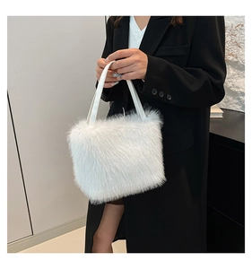 Detail of white faux fur shoulder bag featuring soft texture and leather handle on a model