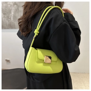 Detail of neon green underarm bag with glossy finish and square gold metal buckle