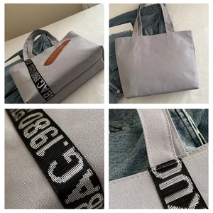 Détails du sac fourre-tout en toile grise avec bandoulières tissées et finitions en cuir