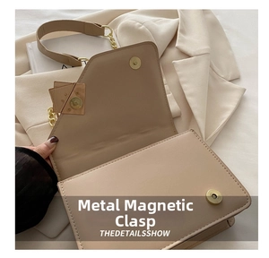 Vista dettagliata della borsa a tracolla in pelle beige con chiusura magnetica dorata
