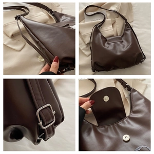 Detail of dark brown faux leather bag showing adjustable strap and magnetic snap buckle