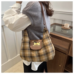 Dettaglio della borsa hobo in tessuto scozzese marrone con cane stampato sulla patta