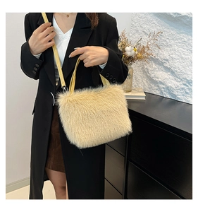 Detail of plush faux fur shoulder bag with contrasting yellow leather straps and hardware