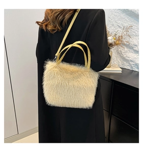 Detail of soft faux fur shoulder bag with mustard leather strap and top handle