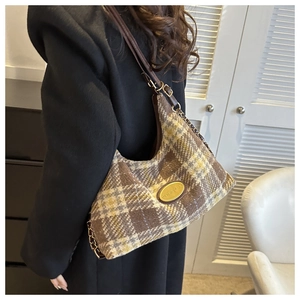 Dettaglio borsa hobo vintage in lana a quadri con logo dorato e tracolla a catena