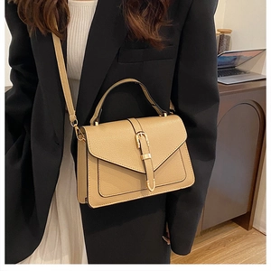 Elegant khaki small square bag with golden buckle styled on model in business attire