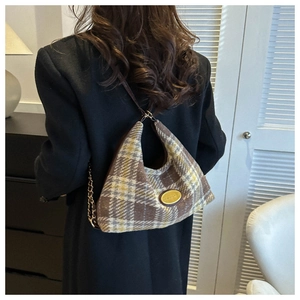 Dettaglio borsa hobo vintage in lana scozzese con placca dorata e tracolla a catena