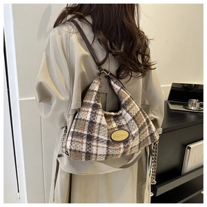 Dettaglio della borsa hobo in tweed a quadri con placca logo dorata e tracolla a catena