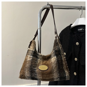 Dettaglio della borsa tote in lana vintage con motivo a quadri marroni e logo dorato