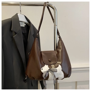 Close-up of brown PU leather tote with cute plush puppy patch and checkered bow detail