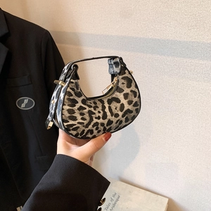 Mini crescent bag with vintage leopard print and metal zipper shown in a handheld view