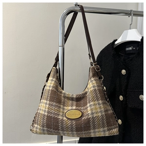 Dettaglio borsa a spalla vintage in lana a quadri con tracolla in pelle e placca oro