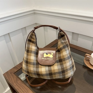 Borsa sottobraccio retrò a scacchi con patta in pelle a fumetti in un ambiente casa