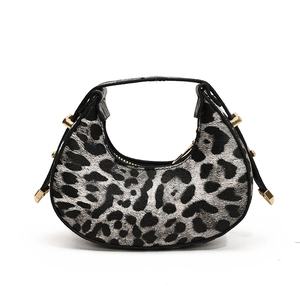Mini crescent handbag with leopard print and golden hardware on a white background