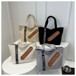 Vue détaillée de grands sacs cabas en toile en quatre couleurs avec sangle et poches zippées