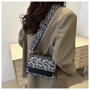 Dettaglio della borsa a tracolla leopardata con ampia tracolla geometrica e patta moda