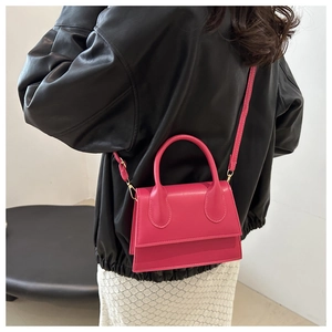Detailed back view of a fuchsia mini flap bag styled with a black leather jacket