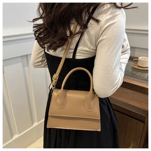 Minimalist beige leather crossbody bag for women with top handle and adjustable strap