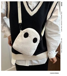 Détail du petit sac fantôme en velours côtelé blanc avec bandoulière sur une tenue