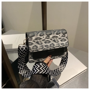 Dettaglio borsa a tracolla leopardata con ampia tracolla jacquard geometrica e ganci metallici