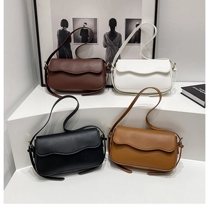 Chic shoulder bags with wavy flap design in four classic colors on display stands