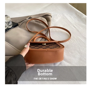 Detail of the durable wear-resistant bottom on this brown checkered saddle bag