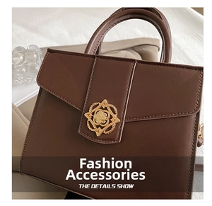 Detail of a brown leather handbag with a vintage gold floral metal clasp and flap design