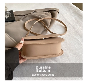 Gros plan détaillé montrant la base durable et les coutures fines du sac à main beige